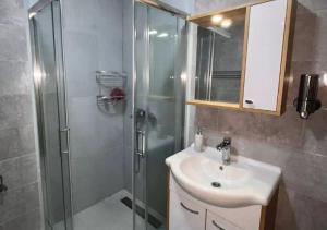 une salle de bain avec une douche et un lavabo et une douche dans l'établissement Apartman FilaLux, à Zlatibor 21 autres photos