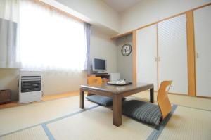 a living room with a table and a chair at Hotel Saharin in Wakkanai