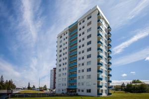 een hoog wit gebouw met blauwe ramen bij Panoramic Studio Apartment with stunning view - Free Parking in Reykjavík