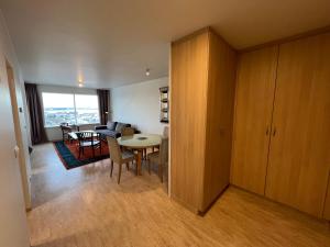 Panoramic Studio Apartment with stunning view - Free Parking في ريكيافيك: غرفة معيشة مع طاولة وغرفة طعام