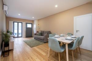 una sala da pranzo con tavolo, sedie e divano di Formosa Apartments by Amber Star Rent a Porto