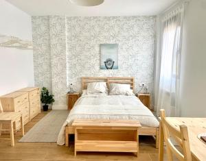 a bedroom with a bed with a wooden bed frame at Casas La Fuente de Saelices - Alojamiento rural in Saelices el Chico