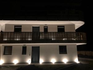 a white building with a balcony at night at Villa Lara Lärche in Castelrotto