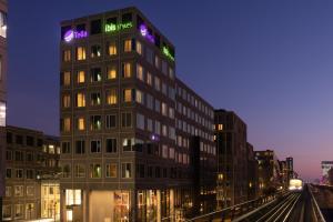 a tall building with a sign on top of it at ibis Styles Copenhagen Orestad in Copenhagen