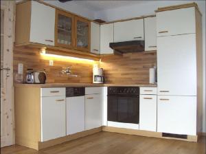 a kitchen with white appliances and wooden walls at Ferienhof Fernblick in Lalling