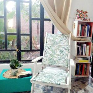 una silla blanca sentada en una habitación con ventana en Relajante y amplio con jardín en 