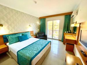 een hotelkamer met een bed en een televisie bij Green Forest Holiday Village in Oludeniz