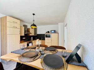 a dining room table with chairs and a kitchen at Ferienwohnung - ländliche Atmosphäre, Geräumig, mit Arbeits- und Parkplatz, Küche, Netflix, perfekt für Gruppen in Bad Staffelstein +3 photos