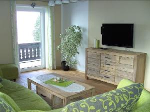 a living room with a couch and a tv at Ferienhof Fernblick in Lalling