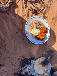 une assiette de nourriture assise dans la saleté dans l'établissement Wadi Rum Star Camp, à Wadi Rum
