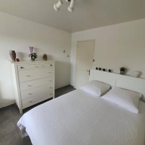 a white bedroom with a white bed and a dresser at Appartement T2 Six Fours Cap Negre,1 mn à pied de la mer in Six-Fours-les-Plages