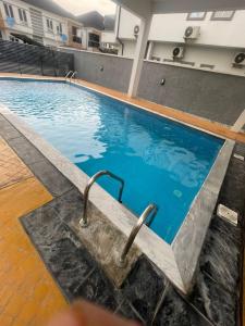 a large swimming pool with two handles in a building at The King's Landing Apartments in Maiyegun