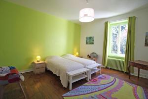 una camera con letto, finestra e tappeto di Haut quarteron a Saint-Junien