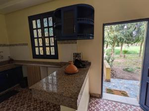 eine Küche mit einer Arbeitsplatte und einem Fenster in der Unterkunft Mesdunes in Azemmour