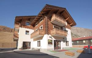 - un bâtiment avec des balcons en bois sur le côté dans l'établissement Chalet Anna Botton d'oro, à Livigno