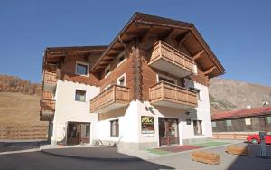 a building with wooden balconies on the side of it at Chalet Anna Botton d'oro in Livigno