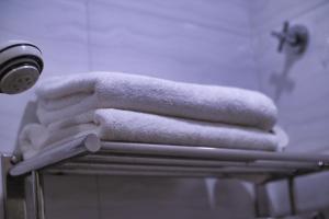 een stapel handdoeken op een handdoekenrek in de badkamer bij Rain Forest Hotel in Kuala Lumpur