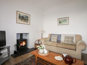 a living room with a couch and a fireplace at Gwynant - Morfa Nefyn in Pwllheli