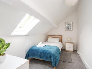 a bedroom with a bed with a blue blanket at Gwynant - Morfa Nefyn in Pwllheli