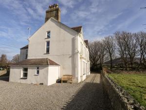 a white house with a tower on top of it at Gwynant - Morfa Nefyn in Pwllheli