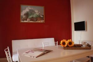 a dining room table with a book and flowers on it at Il Fosso in Borghetto Santo Spirito