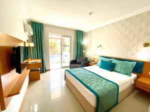 een hotelkamer met een bed en een stoel bij Green Forest Holiday Village in Oludeniz