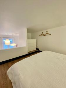 um quarto com uma cama branca e uma janela em REIMS CATHEDRALE - Mairie / Boulingrin em Reims
