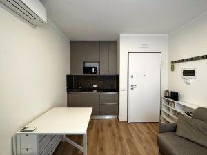 a small apartment with a desk and a kitchen at Extravaganza Room and Suite Apartment City Center in Cagliari