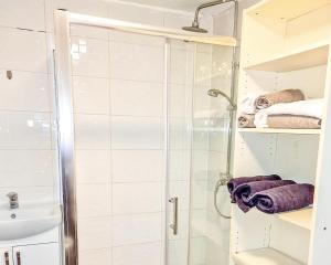 um chuveiro com uma porta de vidro na casa de banho em Stunning 3-Bed House in London with free parking em Croydon