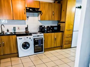 a kitchen with a dishwasher and a washer at Stunning 3-Bed House in London with free parking in Croydon