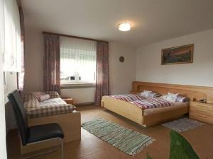 um quarto com 2 camas e uma cadeira em Haus Schmid em Falkenfels