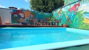 a swimming pool with a mural on the side of a building at Oceanic Hostel in Balneário Camboriú