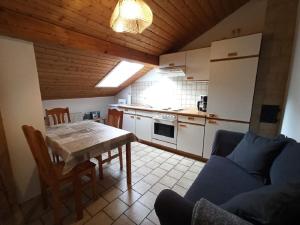 eine Küche mit einem Tisch und einem Sofa in einem Zimmer in der Unterkunft Haus Schmid in Falkenfels