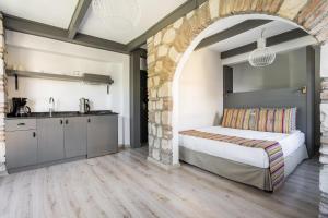 a bedroom with a bed and a stone wall at Lovely Studio Flat near Hadrians Gate in Antalya