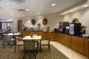 a restaurant with tables and chairs and a kitchen at Wingate by Wyndham Little Rock in Little Rock