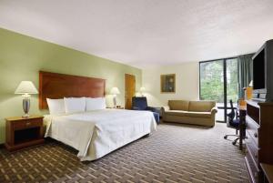 a hotel room with a bed and a television at Days Inn by Wyndham Fayetteville-South/I-95 Exit 49 in Fayetteville