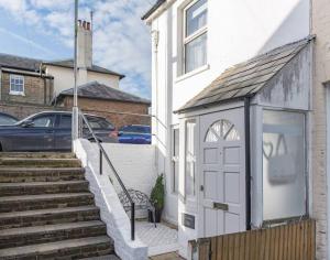 a white house with a white door and stairs at Seabreeze Cottage in Walmer