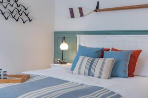 sypialnia z łóżkiem z niebieskimi i pomarańczowymi poduszkami w obiekcie Seabreeze Cottage w mieście Walmer