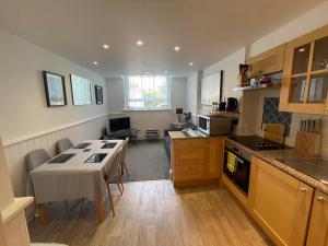 a kitchen with a table and a living room at SUPER Duplex Central City Apt FREE PRIVATE parking in Plymouth