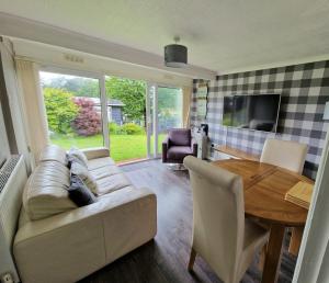 ein Wohnzimmer mit einem Sofa und einem Tisch in der Unterkunft Ranger - Snowdon Cabins holiday let Caernarfon in Caeathro