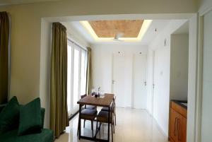 a dining room with a table and chairs and a window at THE TERRACE MANJERI in Manjeri