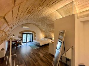 a room with a bed and a desk in a room at Dammusu Marchesi di Sant' Elia, patrimonio UNESCO in Ragusa