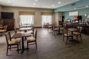 een eetkamer met tafels en stoelen en een bar bij Caper House Inn in Augusta