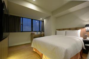 a bedroom with a large white bed and a window at Smile Inn - Taipei Main Station in Taipei