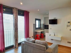 salon z kanapą i kuchnia z oknami w obiekcie Sabaris, Baiona, estudio diseño, parking privado, piscina w mieście Baiona