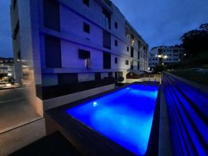 niebieski basen przed budynkiem w obiekcie Sabaris, Baiona, estudio diseño, parking privado, piscina w mieście Baiona