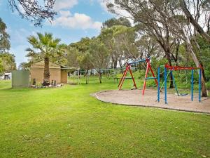 a park filled with lots of green grass and trees at Acclaim Pine Grove Holiday Park in Esperance
