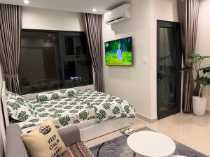 a bedroom with a bed and a tv on a wall at Vinhome Grand Park Homestay House in Gò Công