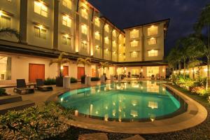 uma piscina em frente a um hotel em The Harvest Hotel Managed by HII em Cabanatuan