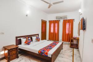 1 dormitorio con 1 cama y TV en FabExpress Goodwill Homes, en Nueva Delhi